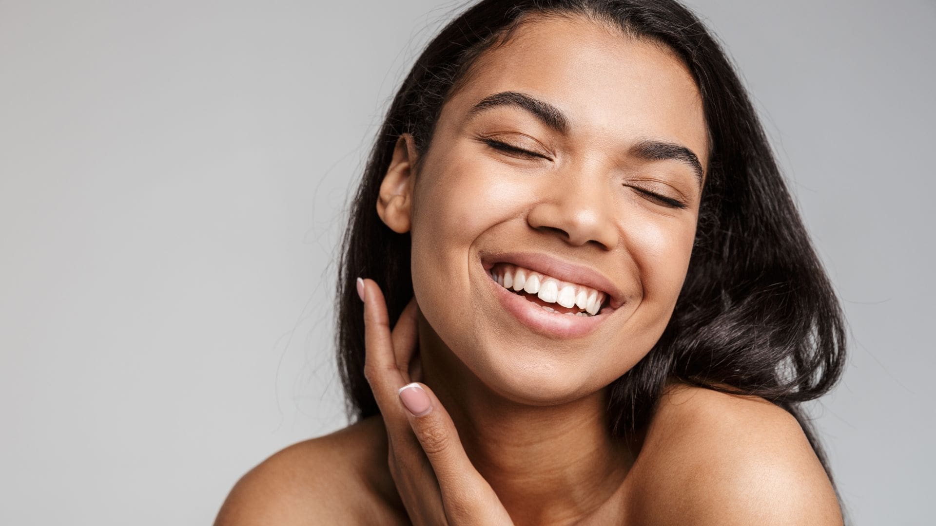 Smiling young woman with clear skin showcases confidence, representing Body Scientific Aesthetics at Towson Med Spa.