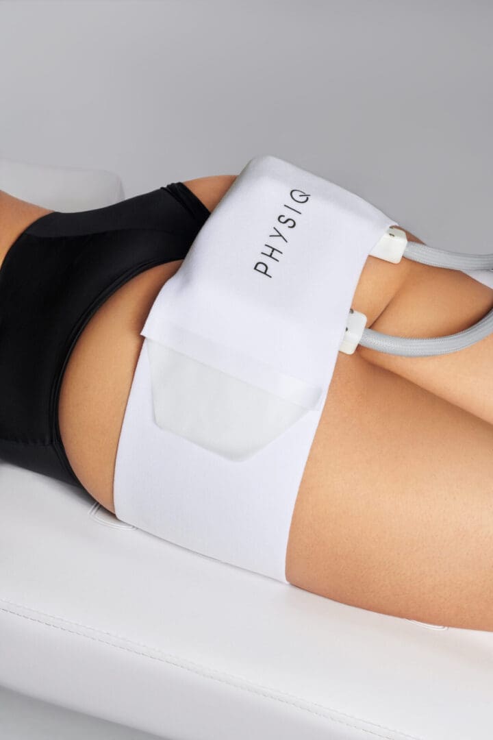Person wearing a Physio 3.0 muscle stimulation belt on their thigh.
