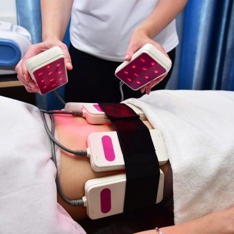 Patient undergoing body contouring treatment with multiple applicators.
