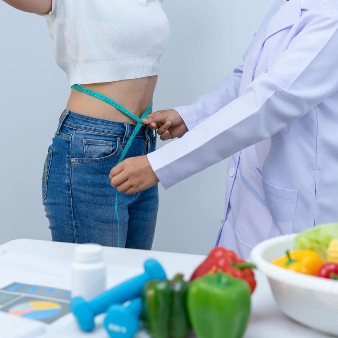 Doctor measuring waist of a woman for health assessment.
