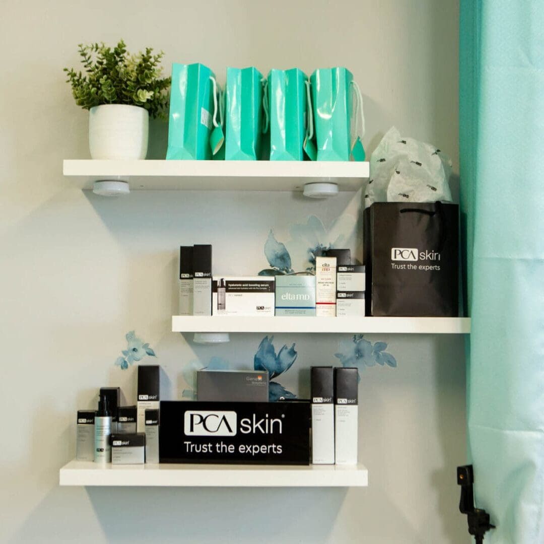 Bathroom shelf with neatly arranged toiletries and a small plant.