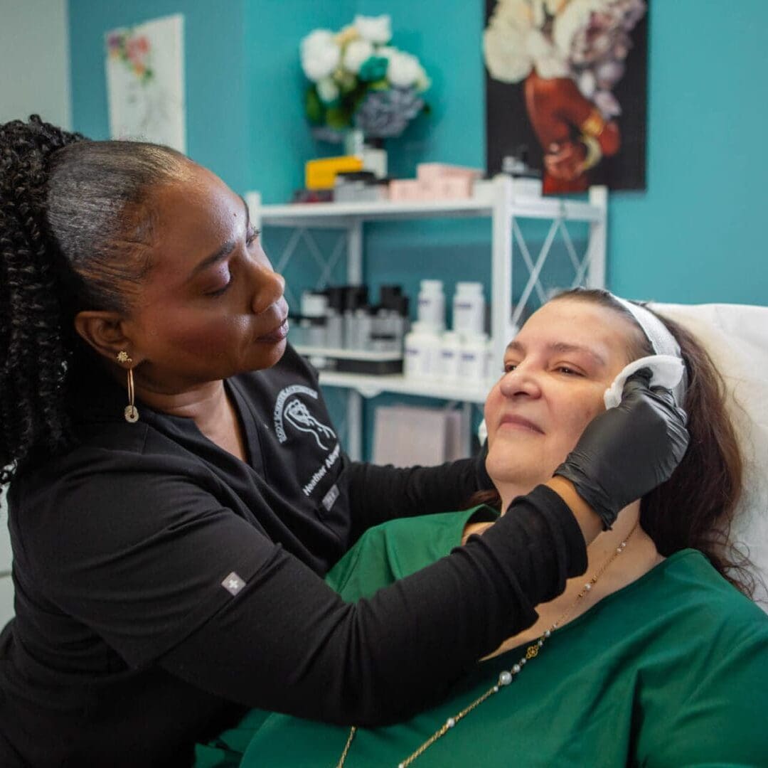 A beautician applies a facial treatment to a client in a cozy salon.