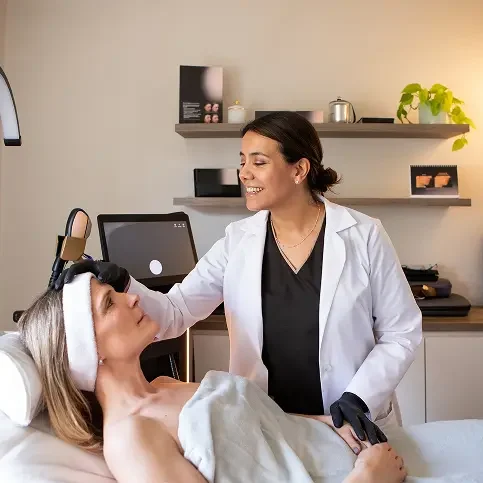 A dermatologist examining a patient's face in a clinic.
