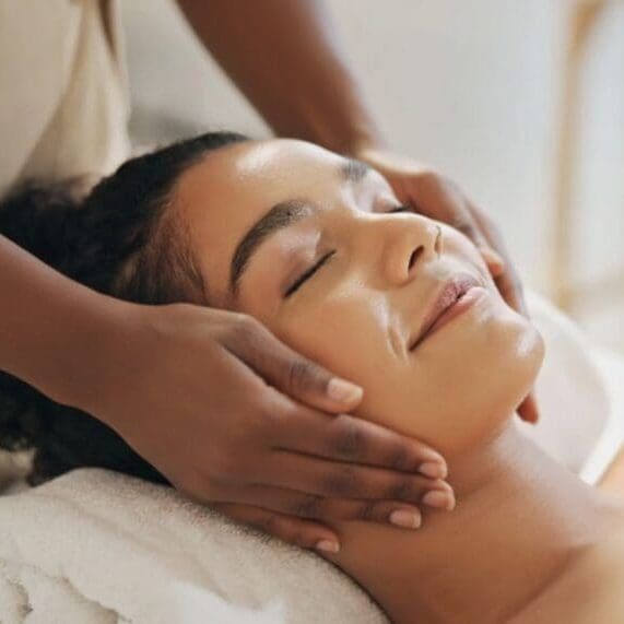 Woman enjoying a relaxing facial massage with eyes closed.
